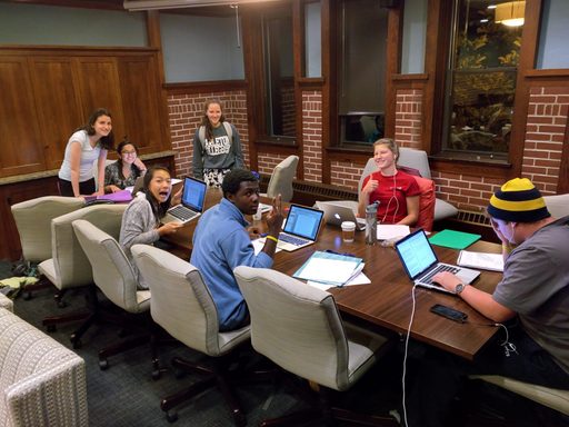 A group of people sit around a conference room table