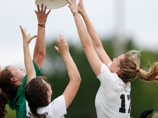 Three ultimate players jump to catch a Frisbee