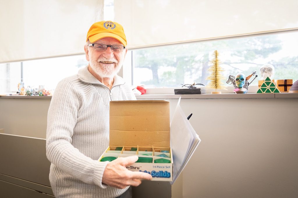 Russ Petricka holding up a puzzle in the Math Skills Center.