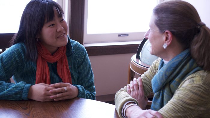 two people talk at a table