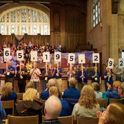 Members of the Carleton Class of 1974 hold up signs that show how much money the class raised for its 50th reunion: $65,195,292.