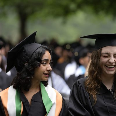 two students laughing together at commencement