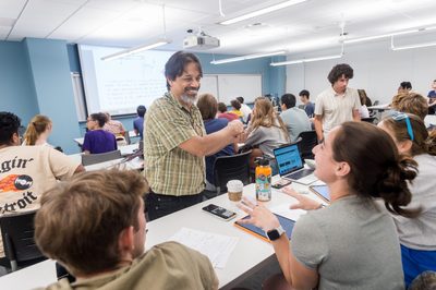 a professor smiles at a student while teaching