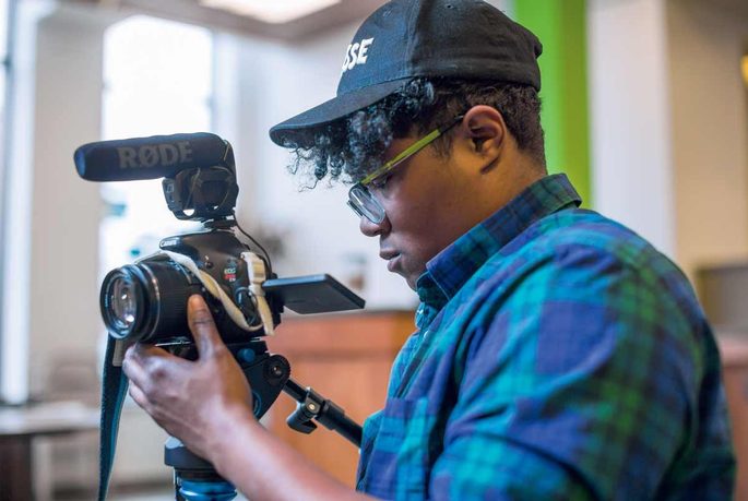 An alum uses a video camera