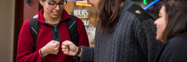 Two students fist bump