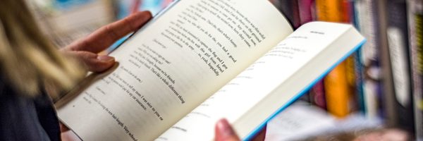 A person flips through a book, pausing on a page with dialogue