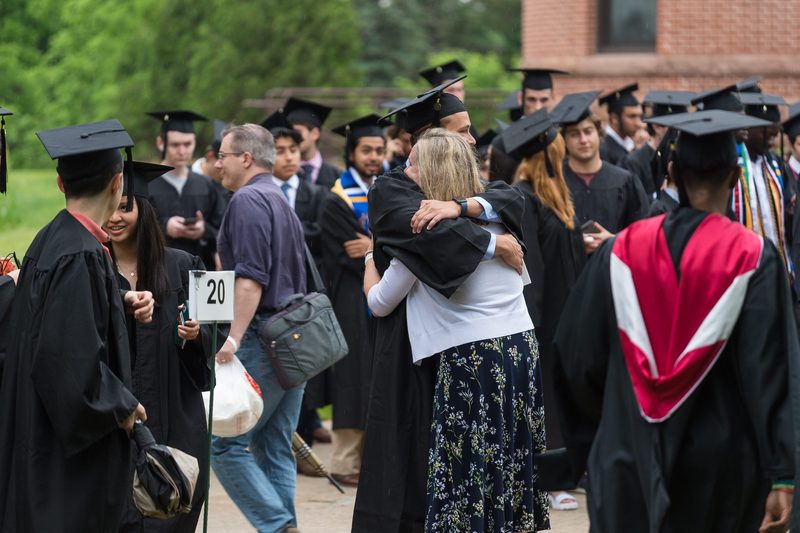 parent hugs student wearing cap and gown