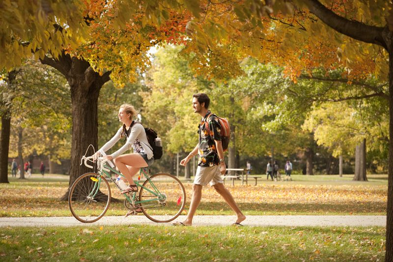 Two students walking by the Bald Spot in the fall