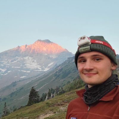 henry looking stoic with a big mountain behind him