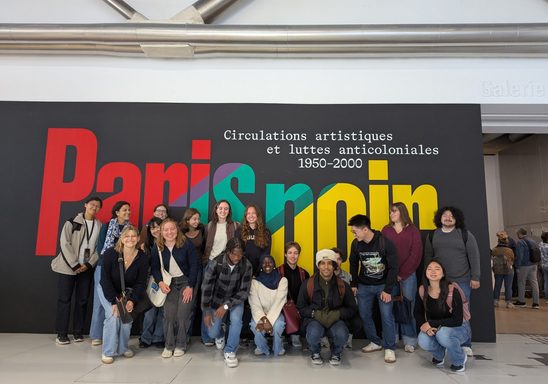 Paris OCS students pose in front of large banner