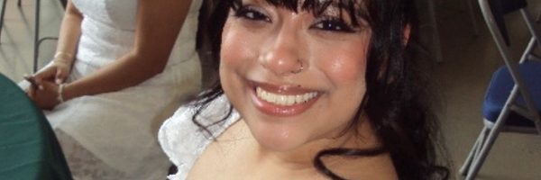 Student with bangs and white dress smiling