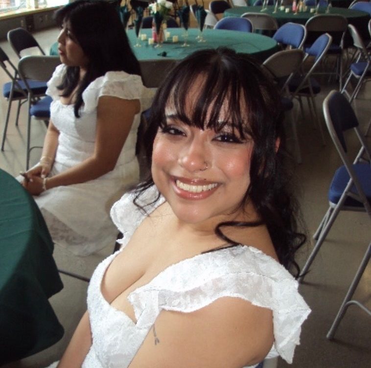 Student with bangs and white dress smiling