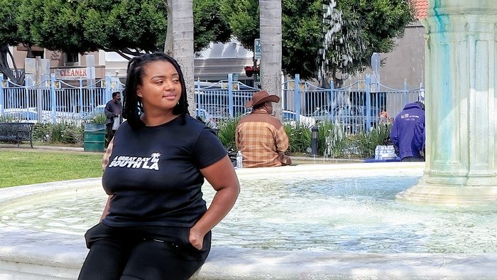 Janae Green sits outdoors on a fountain