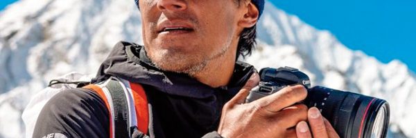Jimmy holding a camera on top of a mountain