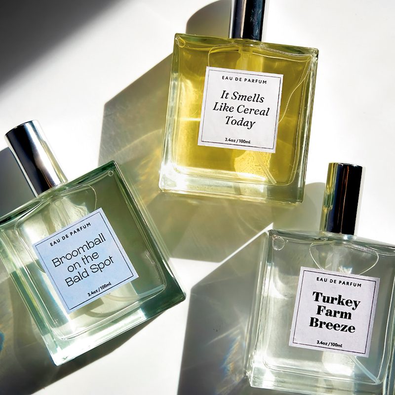 Three bottles of perfume with Carleton-related labels: Broomball on the Bald Spot, It Smells Like Cereal Today, and Turkey Farm Breeze