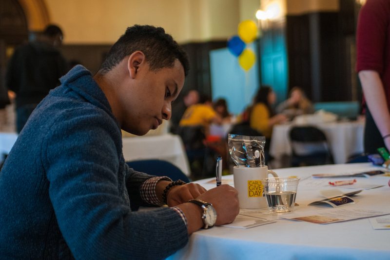 A student writing at a table
