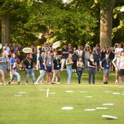 Photo taken from across the Bald Spot of students throwing their frisbees in the NSW frisbee toss.