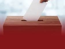 a hand dropping an envelope into a box