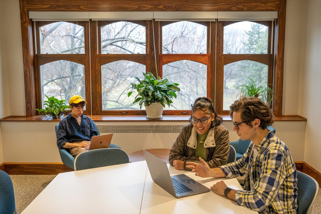 college students on laptops spread out around a conference room