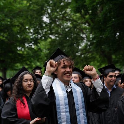 Student cheering on others at Commencement