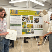 Two students standing in front of a poster
